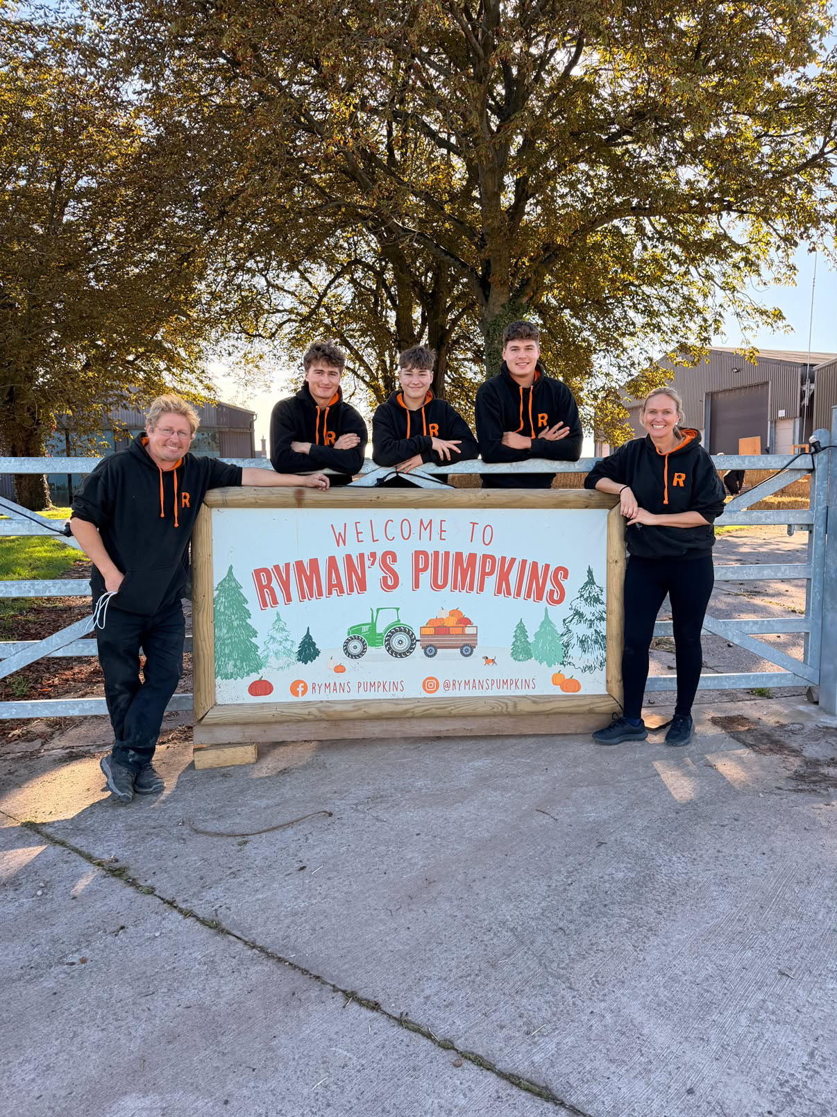 The Rymans family in front of the Welcome to Ryman's Pumpkins sign
